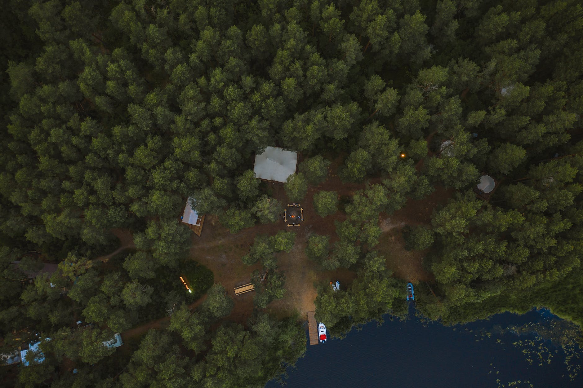 aerial view of green trees surrounding a campsite