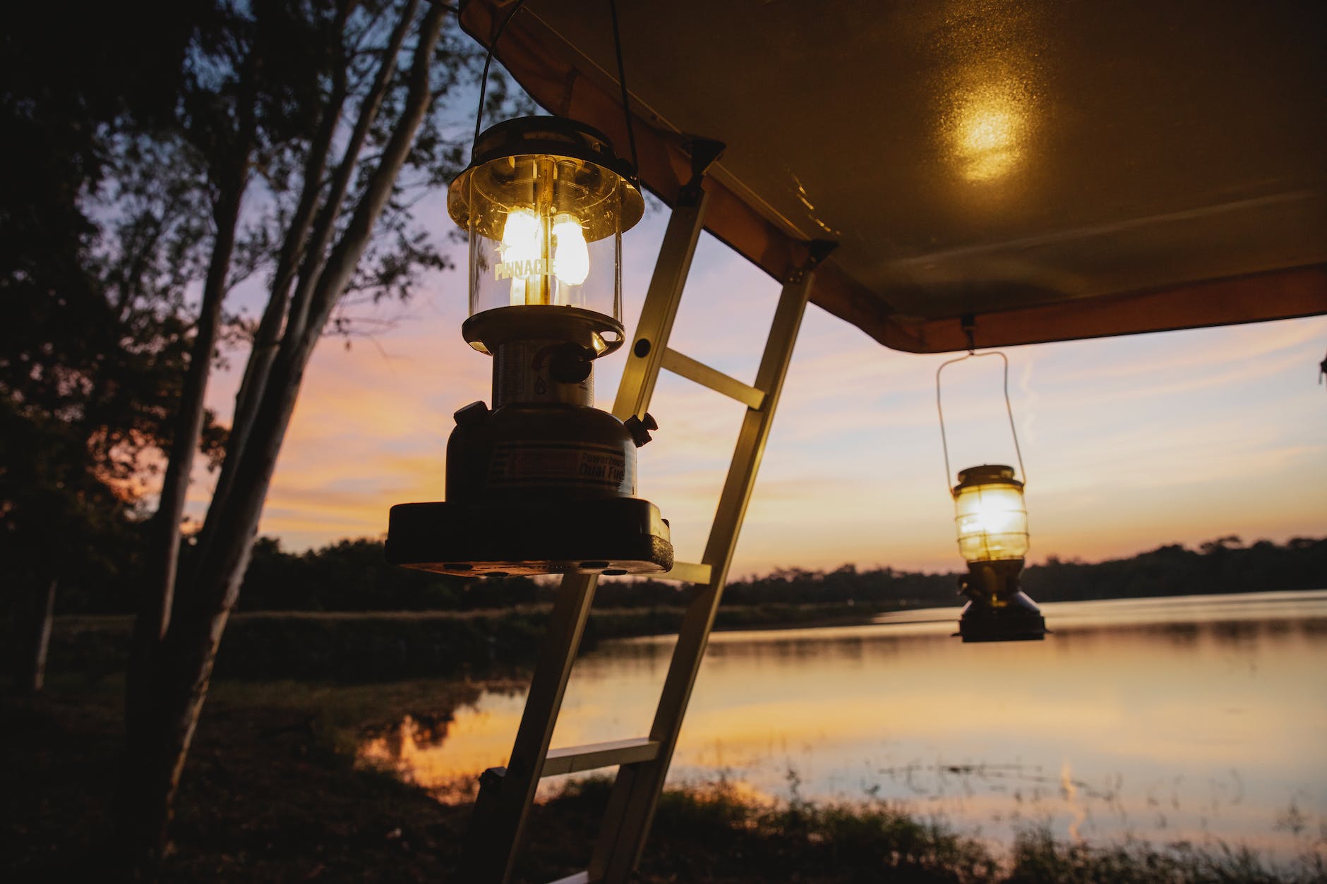 tent with lamps on coast of lake