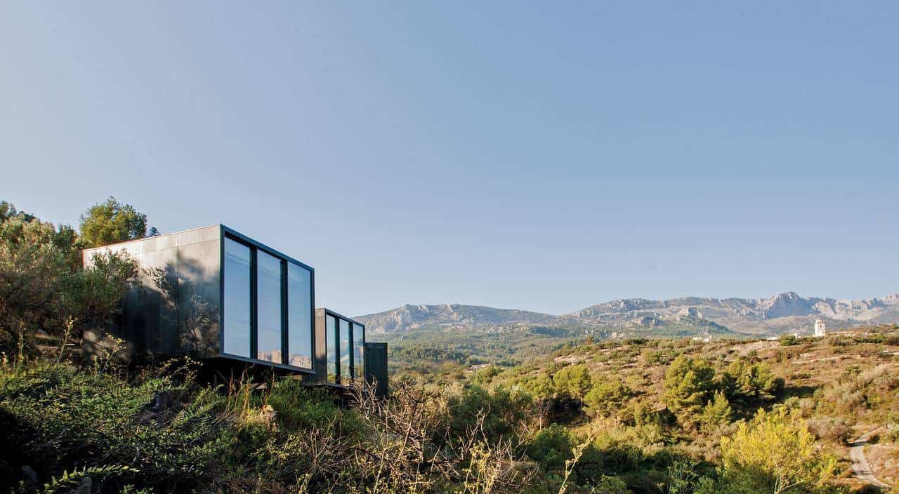 A breathtaking view of Vivood Landscape Hotel in Spain, where modern glass-fronted suites blend seamlessly into the rolling hills. Designed for eco-conscious travelers, this sustainable retreat offers luxury, privacy, and unparalleled nature immersion.