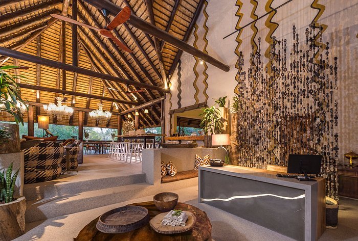 A beautifully designed open-air lodge with intricate African-inspired decor, showcasing natural materials and a welcoming atmosphere. Sage Outdoor Advisory evaluates feasibility studies for boutique glamping resorts with unique designs.