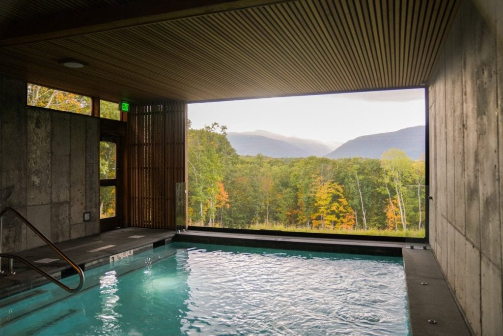 Experience tranquility at this luxury landscape hotel, featuring an indoor-outdoor pool with breathtaking views of lush forests and rolling mountains. A perfect retreat for relaxation, wellness, and nature immersion. Blog post by Sage Outdoor Advisory, offering Glamping and RV Feasibility Studies