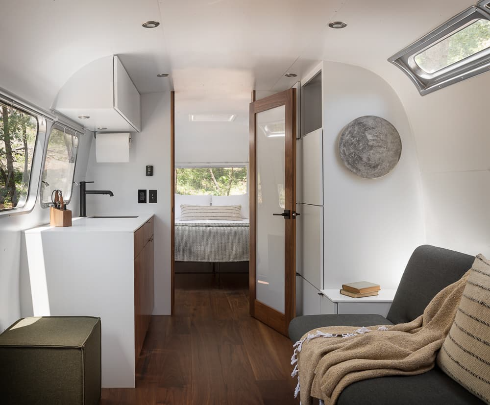 Sleek interior of a glamping Airstream suite with modern kitchen and bedroom—used in Sage Outdoor Advisory’s feasibility study insights for profitable glamping accommodations.