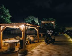 A cozy nighttime scene at Soul Stay's glamping resort in Sandusky, Ohio, featuring illuminated fire pits, wooden pergolas, and lakeside seating areas along the boardwalk. This unique hospitality concept was supported by a feasibility study conducted by Sage Outdoor Advisory, helping validate the demand for elevated glamping experiences in urban waterfront settings.