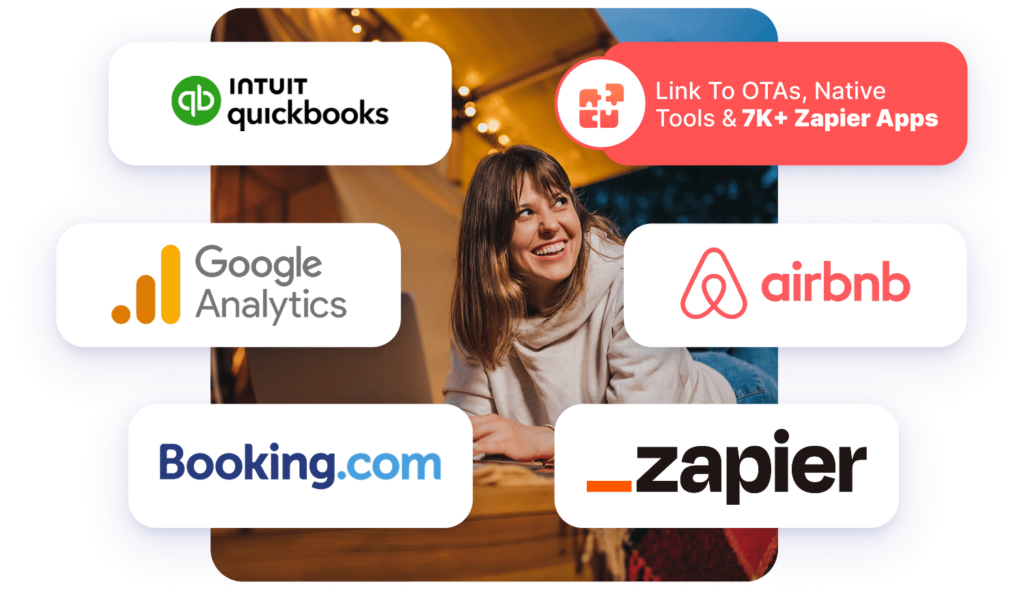 An image graphic featuring various software integration logos overlaid around a photo of a smiling woman looking up from her laptop. The logos shown in white rounded boxes include Intuit QuickBooks, Google Analytics, Airbnb, Booking.com, and Zapier. A pink badge in the upper right reads "Link To OTAs, Native Tools & 7K+ Zapier Apps".